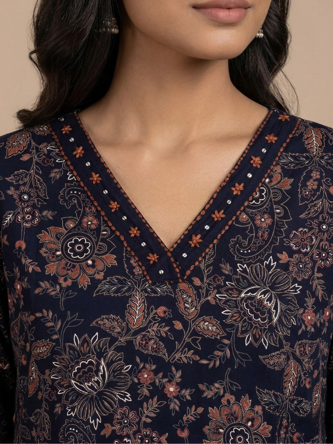 Navy blue floral patterned top with intricate details on a neutral background