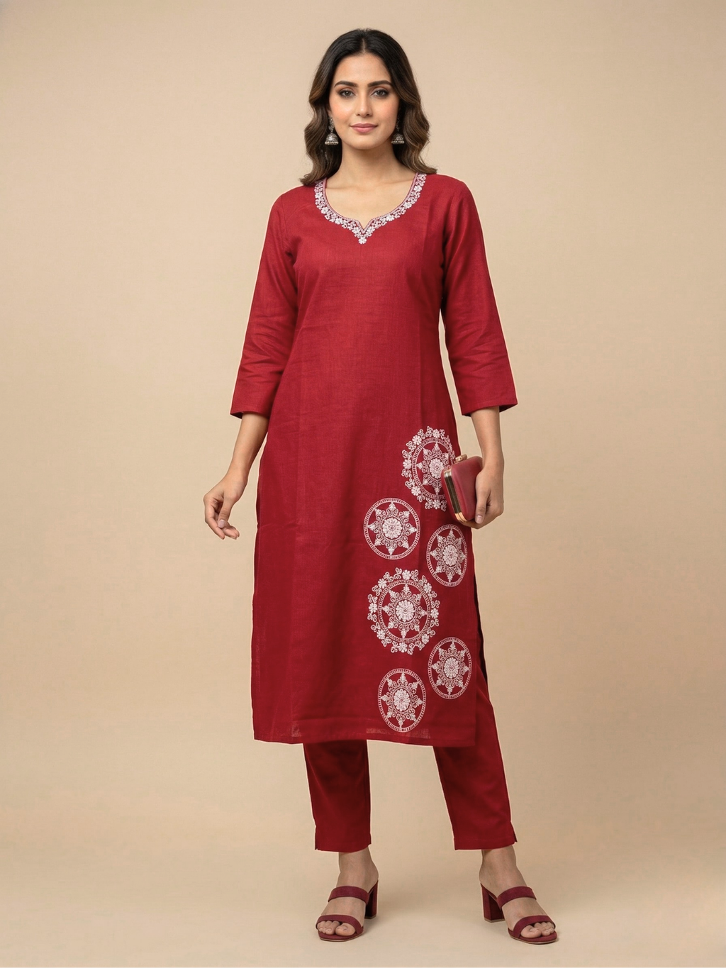 Woman wearing a red kurta with white embroidery on a beige background