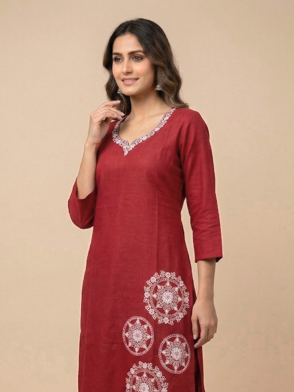 Woman wearing a red kurta with white embroidery on a beige background