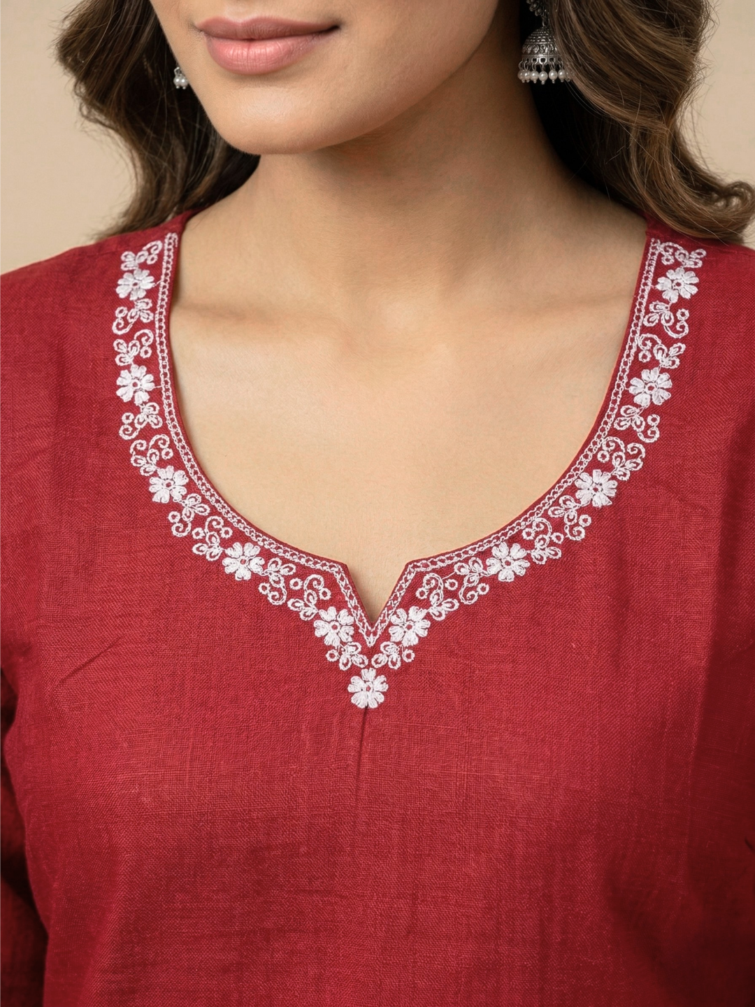 Red kurta with white floral embroidery on a beige background
