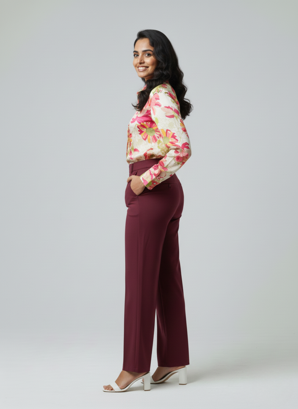 gray parrot shirt Woman wearing a floral blouse and maroon pants on a white background