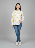 gray parrot shirt Woman wearing a white shirt with yellow patterns and blue jeans on a gray background