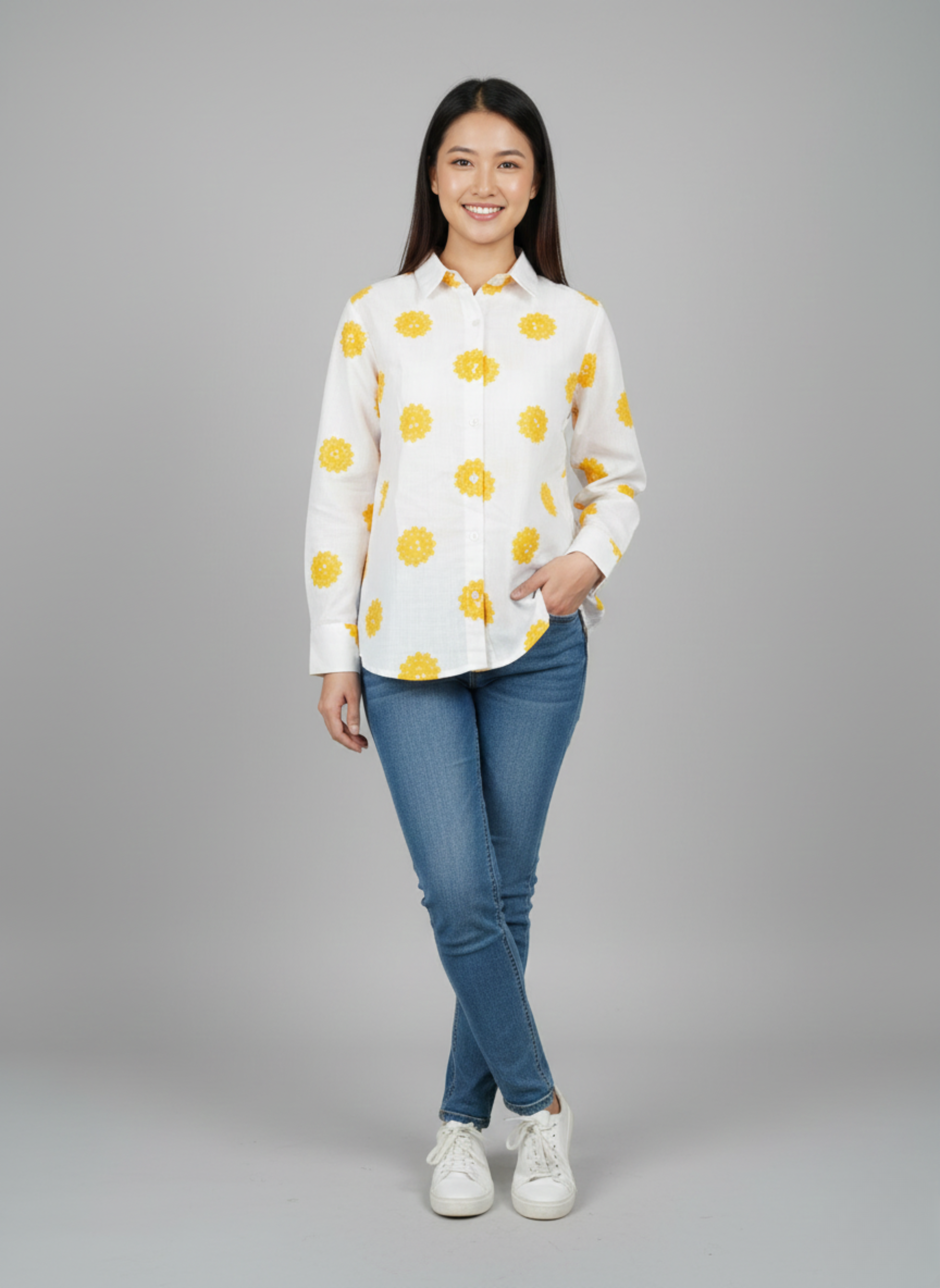 gray parrot shirt Woman wearing a white shirt with yellow patterns and blue jeans on a gray background
