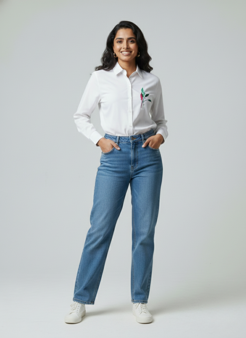 gray parrot shirt Woman wearing a white shirt with a colorful design and blue jeans on a plain background