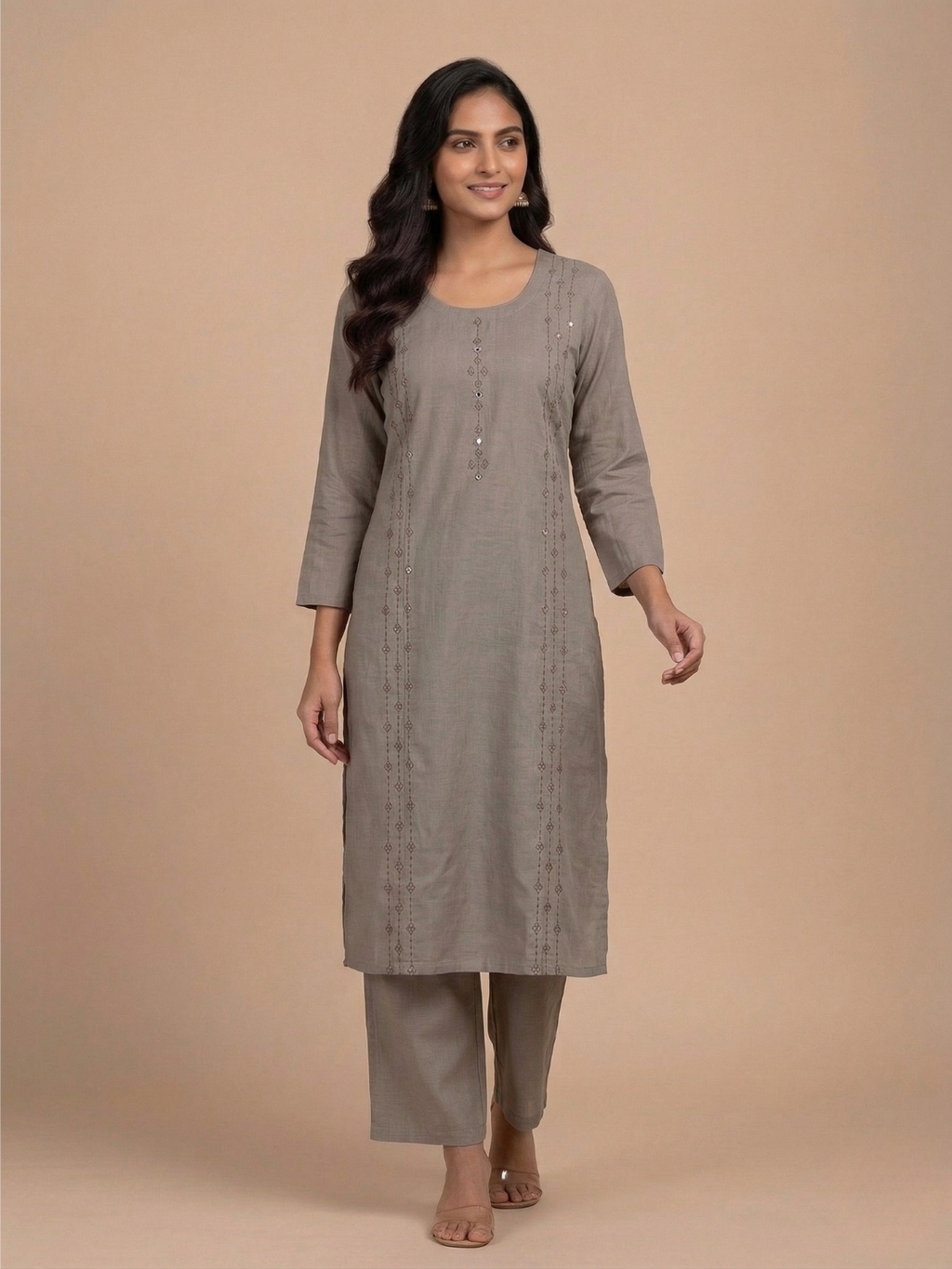 Woman wearing a gray kurta with pants on a beige background