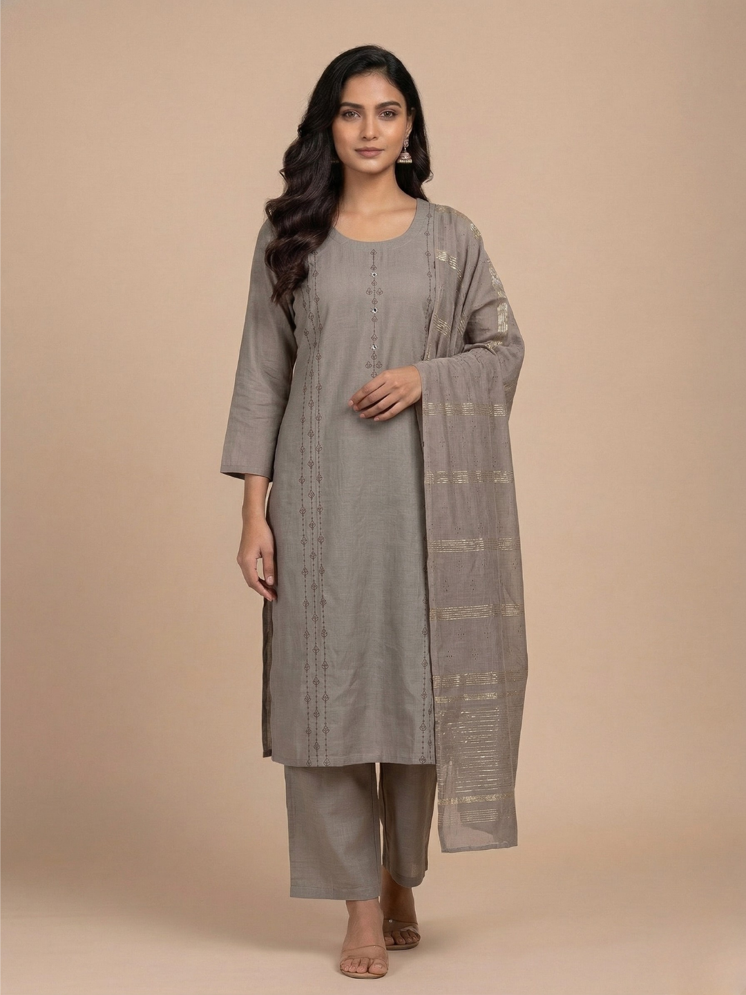Woman wearing a gray kurta with a matching drape against a beige background