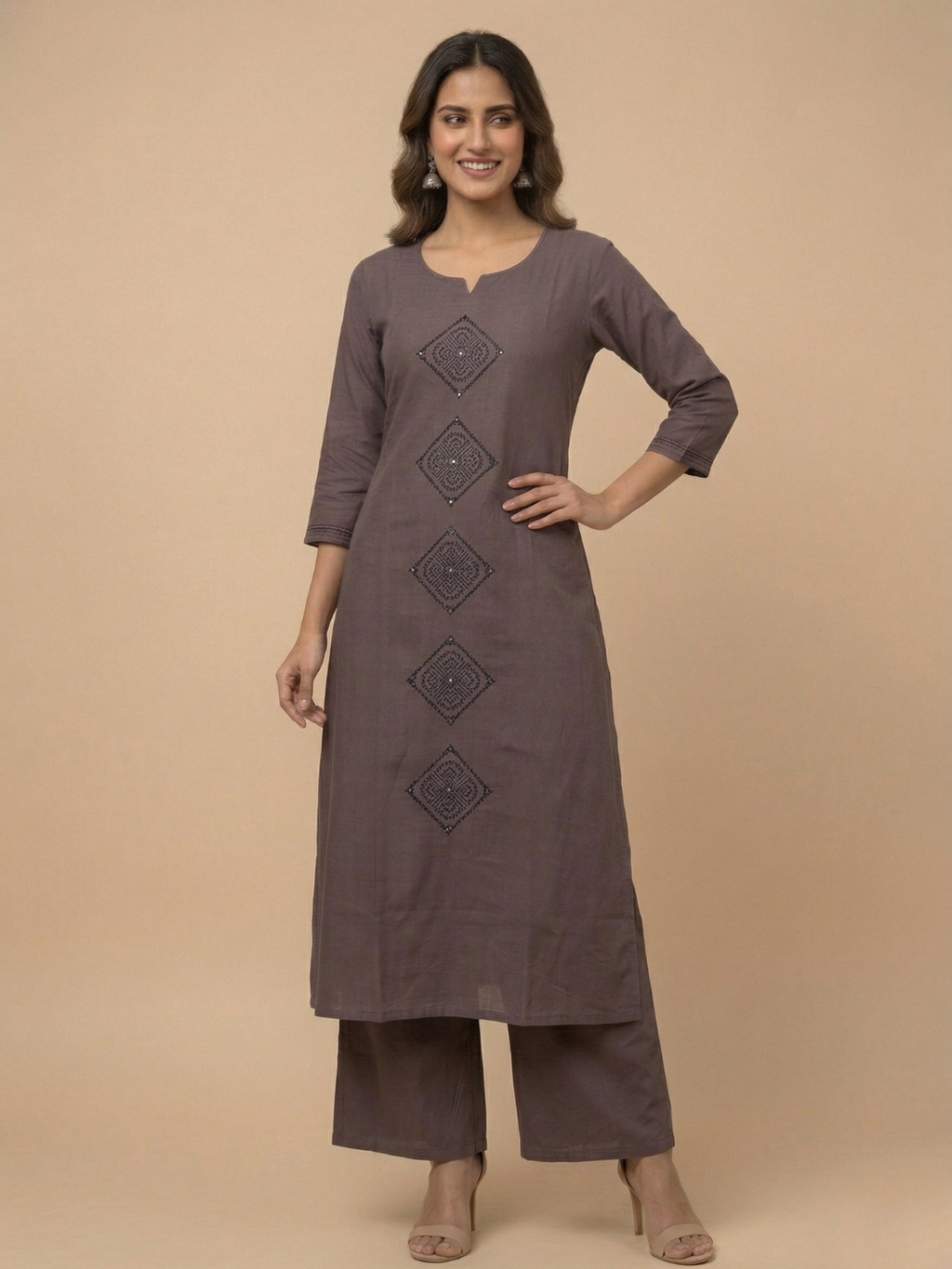 Woman wearing a brown kurta with decorative elements on a beige background