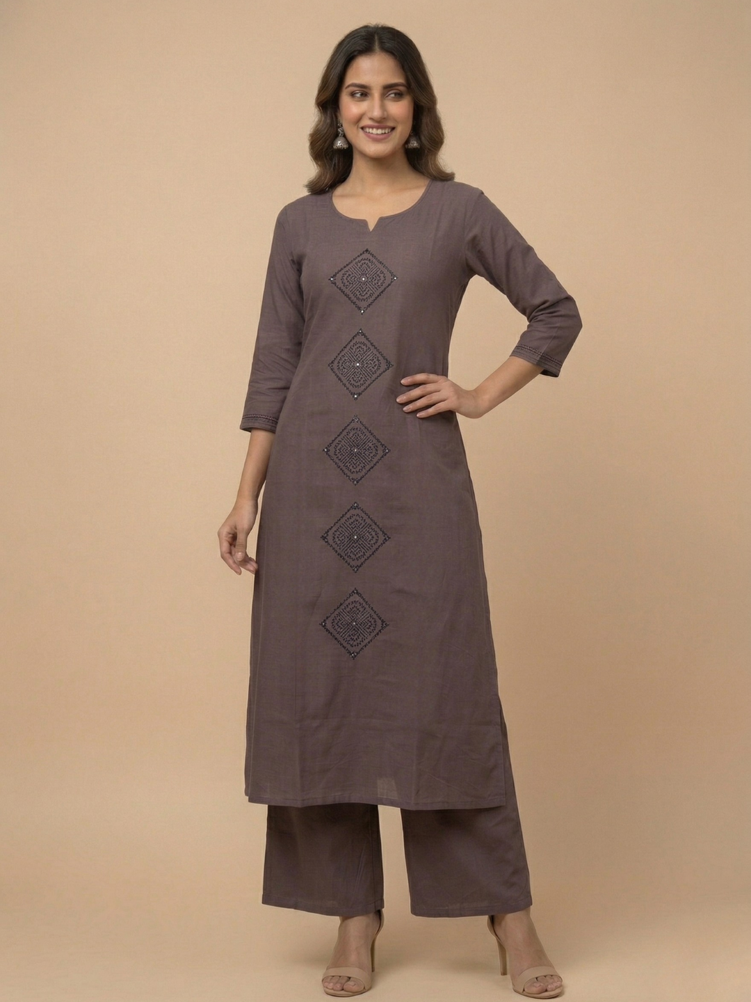 Woman wearing a brown kurta with decorative elements on a beige background